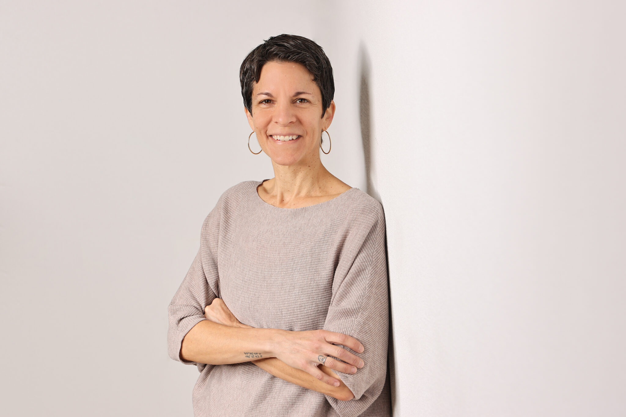 Kristen Lmabertin's portrait photography while leaning against the grey wall